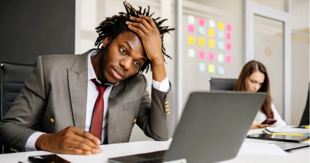 Office worker experiencing stress and fatigue while working at a laptop, illustrating early signs of burnout