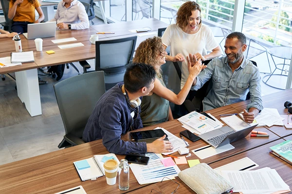 coaching-for-organisations-london-team Diverse team working well together and sharing a high five, the result of business coaching services for organisations